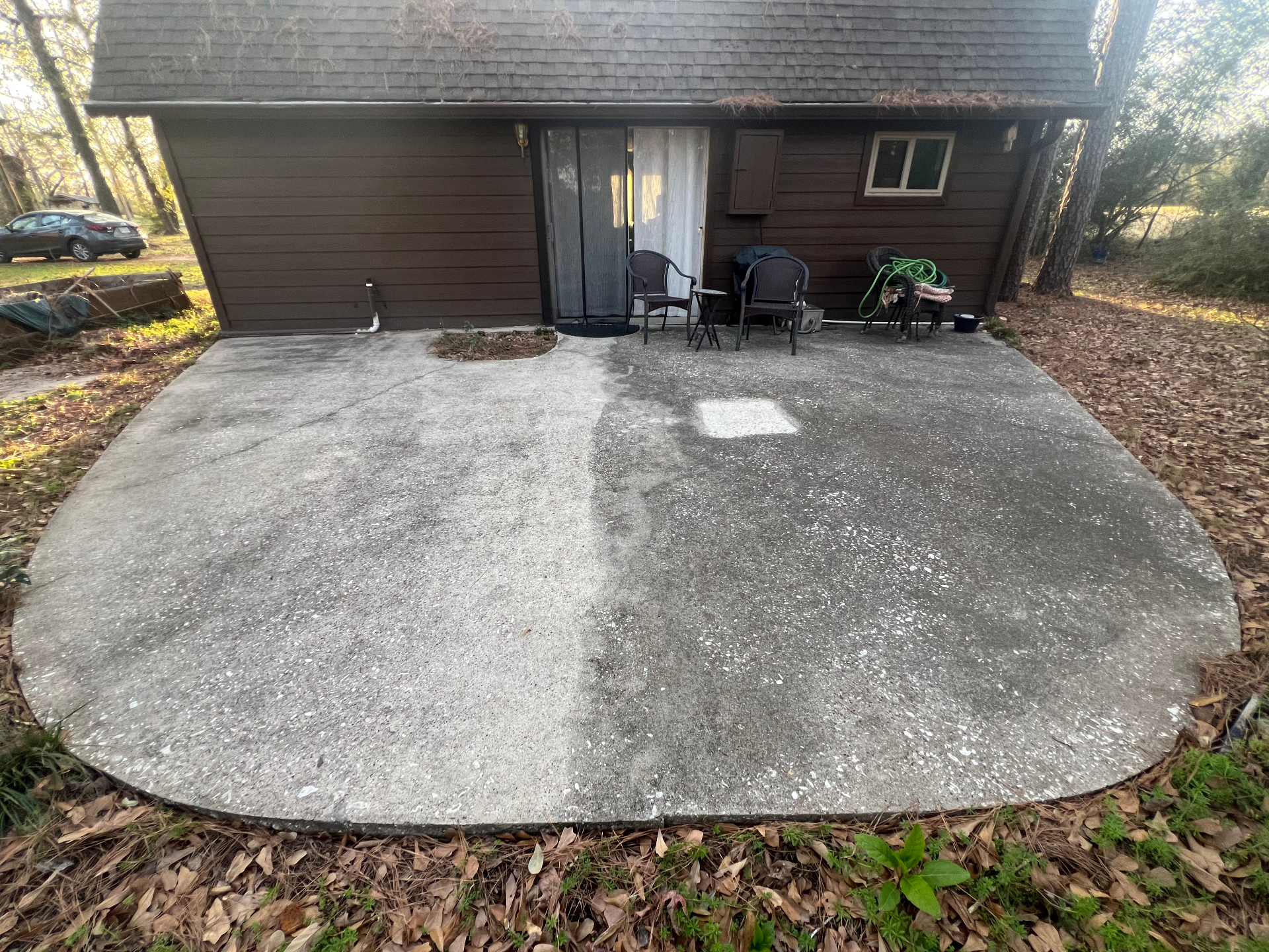 Patio in early spring at thirty-one months, sealed half still visibly cleaner than unsealed control after three winters